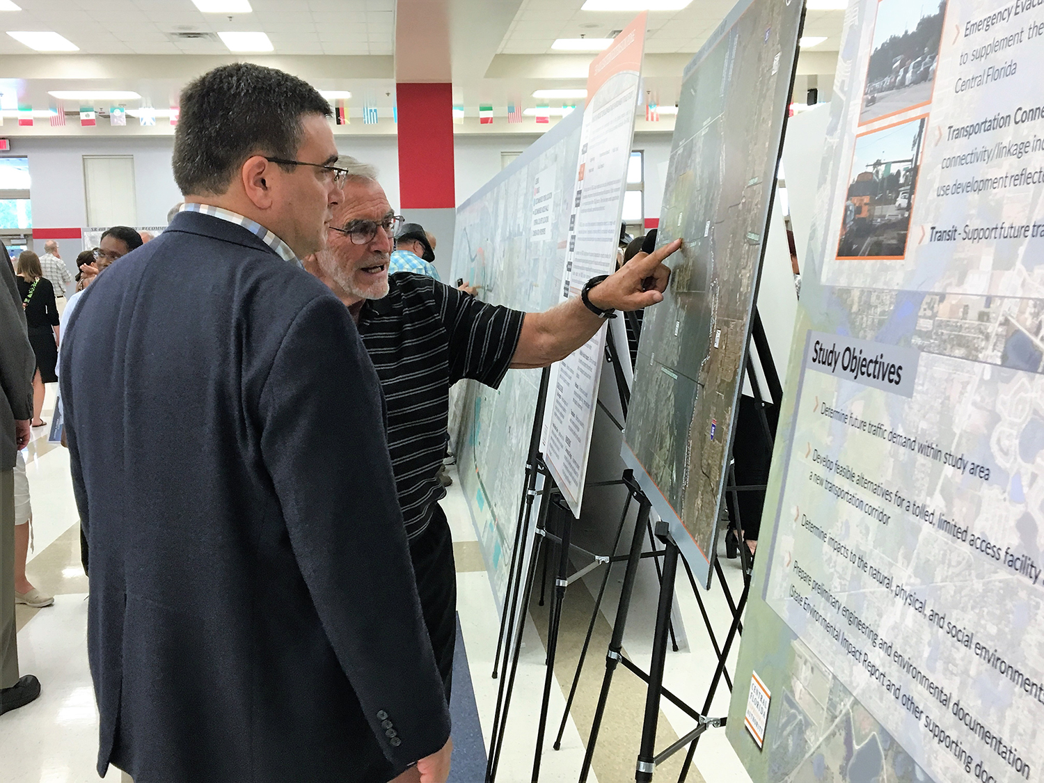 Citizens study maps of the PD&E Study for State Road 408 Eastern Extension during a public meeting